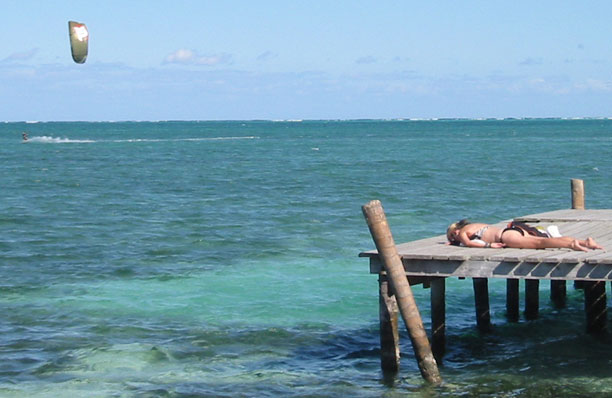 Mel sunning on taxi dock with kite surfer in background
